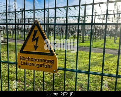 Warnschild Hochspannung Lebensgefahr an Sicherheitszaun von Umspannwerk für Stromversorgung, Nordrhein-Westfalen, Deutschland Stockfoto