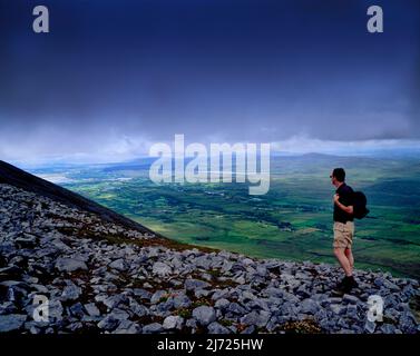 Ein Mann steht auf dem Gipfel des Muckish Mountain im County Donegal, Irland Stockfoto