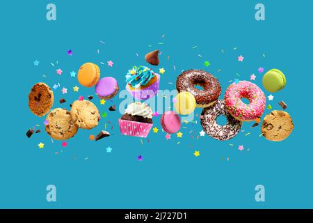 Donuts, Cupcakes, Kekse, Makronen fliegen über blauen Hintergrund. Stockfoto