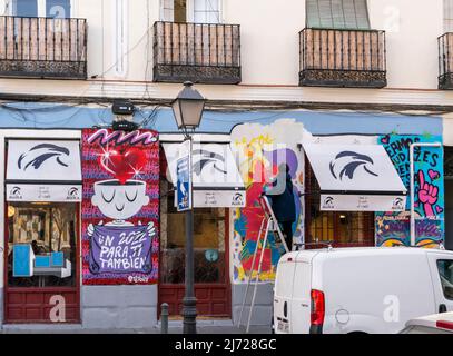 Ein Straßenkünstler, der frisches Wandgemälde auf einer Leiter versprüht, steht an der Restaurantwand des „Donde da la vuelta el viento“, Lavapiez, Madrid, Spanien Stockfoto