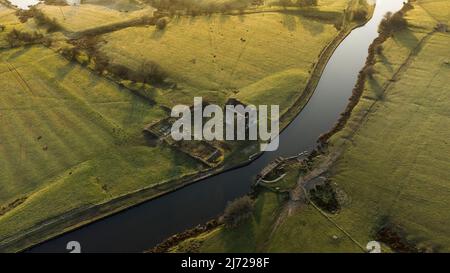 Luftaufnahme der alten, kanalseitigen Farm-Ruine der Lower Clough Bank am Ufer des Leeds-Liverpool-Kanals in Altham, Lancashire. England Stockfoto