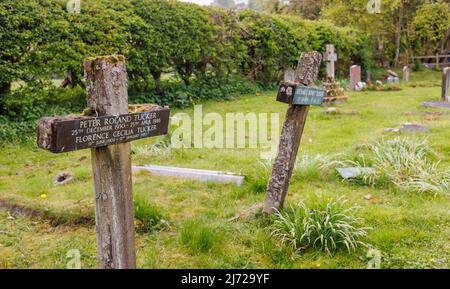 Holzkreuze auf Gräbern auf dem Kirchhof der Pfarrkirche St. Michael und All Angels in Shelbourne, einem kleinen Dorf im ländlichen Wiltshire, England Stockfoto