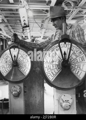Die Großen Propeller wenden sich erstmals - Werftingenieur auf der Brücke von den Vereinigten Staaten Lines neuer 990 Fuß superliner Vereinigte Staaten, Steht am Telegrafen des Maschinenraums bereit, um das Signal zu geben, dass die großen Motoren zum ersten Mal die Propeller drehen werden, während das Schiff ihre Dock-Tests - den ersten Atemzug des Lebens - bei den Newport News durchläuft, VA. Shipbuilding and Dry Dock Company, wo sie kurz vor der Fertigstellung steht. Die Vereinigten Staaten sollen New York am 3. Juli auf ihrer Jungfernfahrt nach Havre und Southampton in den USA Lines Transatlantic Servicic verlassen Stockfoto