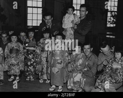 BCOF-Ingenieure ***** Japanische Kinder ihrer Mitarbeiter während der Weihnachtszeit. Von links nach rechts: Pte. R. K. Howe (Campsie, NSW), Corporal A. J. Smith (Northcote, Melb.), Corporal B. Witherden (Coburg, Vic.) und Sapper K. Ireland (Brisbane). 8. Februar 1949. (Foto von Public Relations Section HQ BCOF). Stockfoto