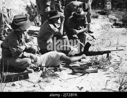 Männer des 3 Mrd. Royal Australian Regiment beobachten das Geschützfeuer der Crew während eines intensiven Trainings in Haramura Japan. Die britische Commonwealth-Besatzungsmacht in Japan wird zur Kriegszeit erhoben und das 3 Milliarden Royal Australian Regiment hat intensiv für die Art von Gelände trainiert, das in Korea abgedeckt werden muss. 13. September 1950. (Foto von Public Relations Section, HQ BCOF Japan). Stockfoto