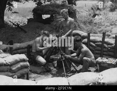 In ihrer sandsackigen Grube auf einer Vorwärtsposition südlich eines Flusses wird eine Mörserbesatzung von 3 Mrd., das Royal Australian Regiment, mit der eifrigen Reinigung ihres Mörtels beobachtet. Pte J (Bluey) Karrelly 229 Barkly Street, East Brunswick, Victoria und Pte S Waterfield, 15 Sussax Street, Coburg, Victoria schenken dem Fass ihre Aufmerksamkeit, während Pte R W Fewson, 8 Alexander Street, Rivervale, WA. 12. Juli 1951. (Foto von Public Relations Section, HQ BCOF Japan). Stockfoto