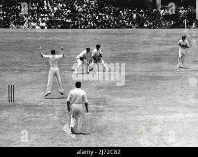 Der südafrikanische Bowler Tayfield springt in der Luft, als der australische Schlagmann A. Morris am ersten Tag des zweiten Tests in Newlands, Kapstadt, von Watkins (rechts) am Ende seiner Innings von 42 erwischt wird. Der südafrikanische Bowler H. Tayfield springt in die Luft, als er am ersten Tag des zweiten Tests in Newlands Kapstadt für 42 von Watkins gefangen wird. Australien gewann durch Innings und 85 Runs. Im Hintergrund laufen die Zuschauer bis zum Rand des Spielbereichs über. 11. Januar 1950. (Foto von African Press Features). Stockfoto