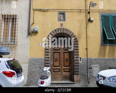 Religiöse, christliche Symbole über dem Eingang zum Wohnhaus in Lucca, Italien. Stockfoto