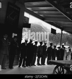 Pontresina -- Leben in den Hochalpen der Schweiz. Abendszene am Bahnhof Pontresina: Die meisten Gäste kommen mit dem 19,5-Uhr-Zug an, und alle Hotels schicken Träger zum Bahnhof. Autos warten draußen auf dem Bahnhofsvorplatz. Der Bahnhof liegt 1803 Meter über dem Meeresspiegel. 22. Januar 1948. (Foto von Pictorial Press). Stockfoto