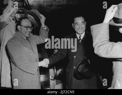 Herr Shunachi Matiumato, der erste japanische Botschafter in London seit 1941, tauscht Handshakes mit Herrn Asaki, dem Leiter der japanischen Mission, aus und hebt seinen Hut vor einem Willkommenskomitee von 20. In L.A.P. heute Abend. 8. Juni 1952. (Foto von Daily Mail Contract Picture). Stockfoto