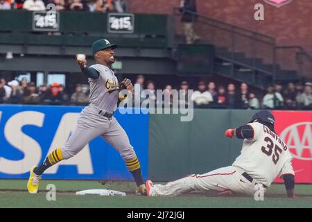 Der zweite Baseman von Oakland Athletic, Tony Kemp (5), stürzt in die erste Basis, während der San Francisco Giant Infielder Brandon Crawford (35) in die zweite Basis gleitet Stockfoto