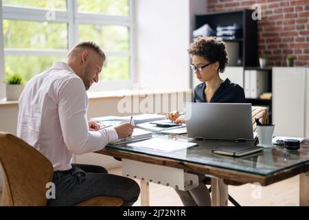 Zwei Kollegen Berechnung der Steuer im Büro Stockfoto