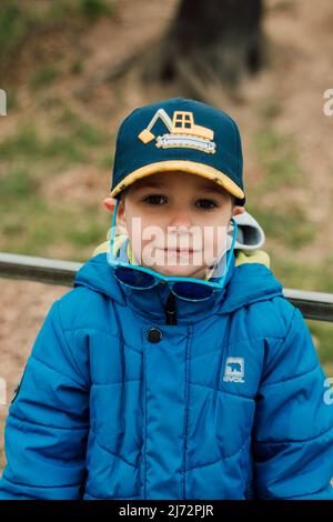 Porträt eines kleinen Jungen mit Sonnenbrille und Mütze Stockfoto