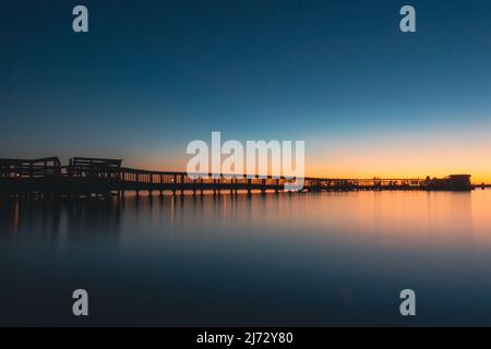 Blauer orangefarbener Sonnenuntergang am Lake Dora Dock in Mount Dora Florida Stockfoto