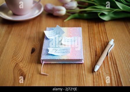 Affirmation, inspirierende Zitate Konzept. Papier mit Motivationsbestätigung und inspirierenden Zitaten auf Holztisch Stockfoto