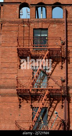 Eine Feuerflucht aus Eisen an der Außenseite eines historischen Backsteingebäudes in San Francisco, Kalifornien. Stockfoto