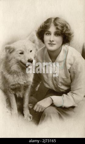 Ein antikes Foto, das eine schöne junge Frau mit ihrem Hund zeigt. ca. 1920 Stockfoto