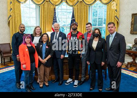 Washington, Vereinigte Staaten von Amerika. 05. Mai 2022. US-Präsident Joe Biden, Mitte, Vizepräsidentin Kamala Harris und Arbeitsminister Marty Walsh, rechts, stellen sich mit einer vielfältigen Gruppe von Basisarbeiterorganisatoren vor, um ihre Bemühungen zur Organisation von Gewerkschaften an ihren Arbeitsplätzen im Oval Office des Weißen Hauses, 5. Mai 2022 in Washington, D.C. zu diskutieren. Quelle: Adam Schultz/White House Foto/Alamy Live News Stockfoto