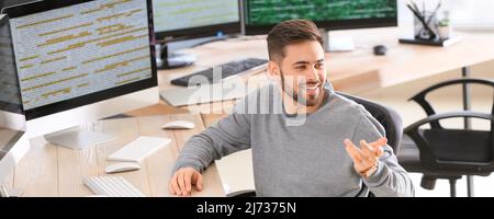 Männlicher Programmierer im Gespräch mit einem Kollegen im Büro Stockfoto