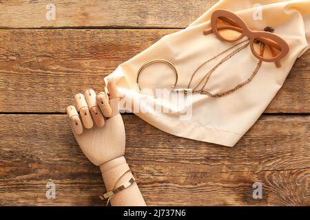 Dekorative Hand mit stilvollen Accessoires auf Holzhintergrund Stockfoto