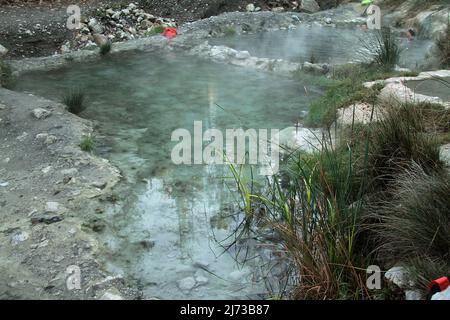 Menschen, die an einem kalten Winterabend in den Pools des berühmten Bagni San Filippo, Italien, baden Stockfoto