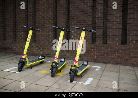 AYLESBURY, Großbritannien - 01. Juli 2021. Vermietung von Elektrorollern (E-Scooter), die auf einem Bürgersteig in einer britischen Stadt geparkt sind. Stockfoto