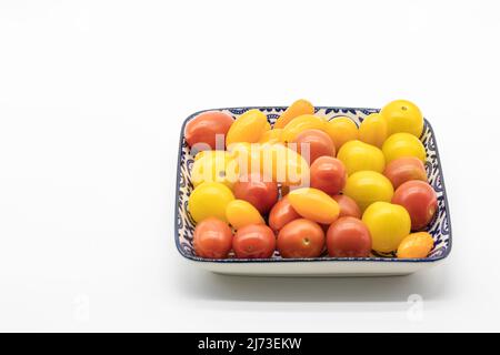 Kirschtomaten in verschiedenen Farben in einer Schrift auf weißem Hintergrund Stockfoto