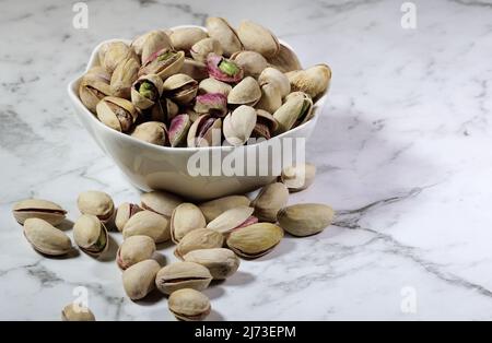 Kleine Schale mit Pistazien auf der Bank Stockfoto