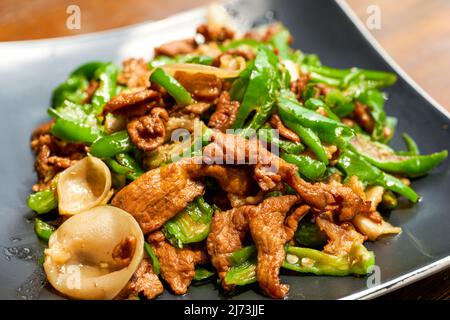 Ein Teller mit köstlichen und würzigen Hunan-Gerichten, gebratenes Schweinefleisch mit Chili Stockfoto