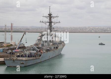 HAFEN VON DSCHIBUTI, Dschibuti (26. April 2022) der Arleigh Burke-Klasse-Lenkflugkörper-Zerstörer USS Gonzalez (DDG 66) erhält Vorräte, während er am 26. April im Hafen von Dschibuti angedockt ist, während das Maritime Expeditionary Security Squadron Ten (MSRON 10) aus Charleston, S.C., das zur Unterstützung von Camp Lemonnier eingesetzt wurde, für Sicherheit sorgt. Der Hafenbetrieb wurde vom Deck des Kommandoschiffs der Blue Ridge-Klasse USS Mount Whitney (LCC 20) aus dem Hafen beobachtet. (USA Navy Foto von Mass Communication Specialist 1. Klasse Christopher Previc) Stockfoto