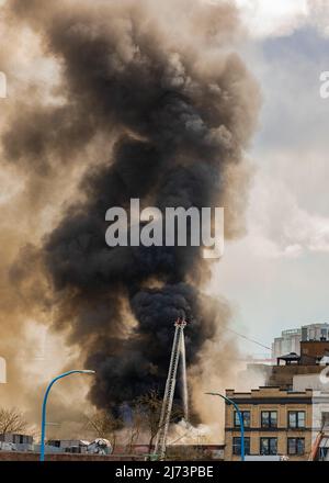 Bilder von Rauch aus einem Feuer in der Stadt. Ein Großbrand, Auswirkungen des Feuers. Der Rauch aus dem Feuer über der Stadt. Straßenfoto, selektiver Fokus, niemand Stockfoto