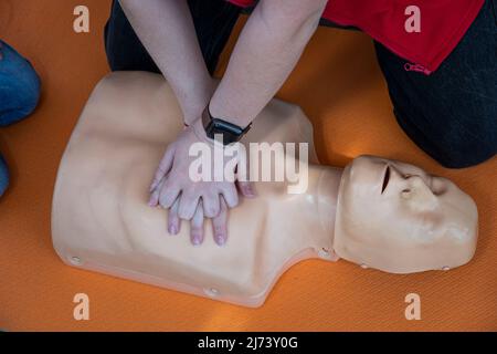 Frau, die CPR an einer Schaufensterpuppe zum Training durchführt. Direkte Herzmassage. Erste-Hilfe-Training auf einem medizinischen Dummy. Herzmassage bei Herzstillstand Stockfoto