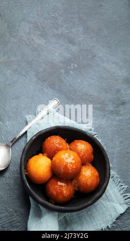 Gulab Jamun auf grauem Hintergrund. Traditionelles orientalisches Speisekonzept. Süße indische Snacks. Draufsicht, flach liegend, Kopierbereich Stockfoto