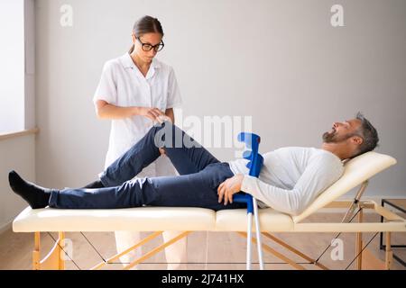 Physiotherapeut Überprüft Das Knie Des Patienten. Physiotherapie Und Schmerzen Stockfoto