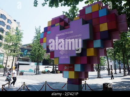 HANGZHOU, CHINA - 19. DEZEMBER 2021 - Bürger kommen an einer Gedenktafel vorbei, die den Countdown für die Asienspiele von Hangzhou 2022 durch den West Lak markiert Stockfoto