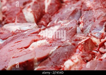 Stücke von frischem Rindfleisch mit Fett liegen auf dem Dorfmarkt auf der Theke. Stockfoto