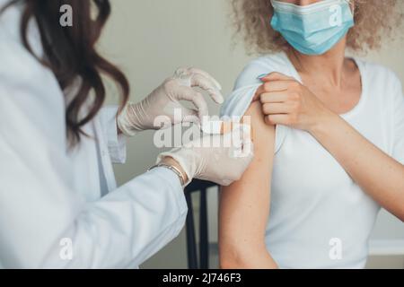 Doctor Stick Medizinisches Pflaster auf den Arm der Frau nach der Impfung. Oronavirus-Pandemieschutzkonzept. Gesundheitskonzept. Corona-Virus Stockfoto