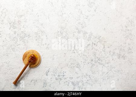 Natürlicher Honiglöffel auf leerem Beton-Hintergrund mit Kopierraum Stockfoto