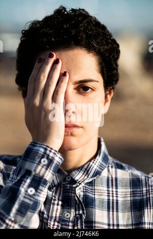 Ernsthafte kurzhaarige Frau, die im Freien auf die Kamera schaut Stockfoto