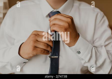 Blonde europäischen kaukasischen jungen Bräutigam in Hemd Business-Anzug mit Krawatte Vorbereitung für die Hochzeit. Ein Mann für eine wichtige Veranstaltung ein Treffen im Haus Stockfoto