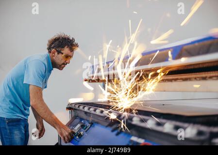 In der Schwerindustrie. Ein Mann arbeitet in einer modernen Fabrik an einer CNC-Maschine. Selektiver Fokus Stockfoto