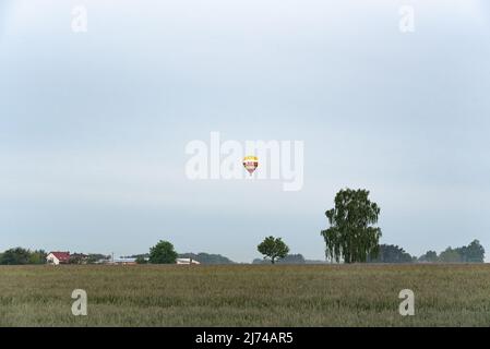 Warschau, Polen - 23. Mai 2020 - Heißluftballon schwebt über den Feldern von Masovia. Polen von einem Heißluftballon aus beobachten. Erholung und aktive lei Stockfoto