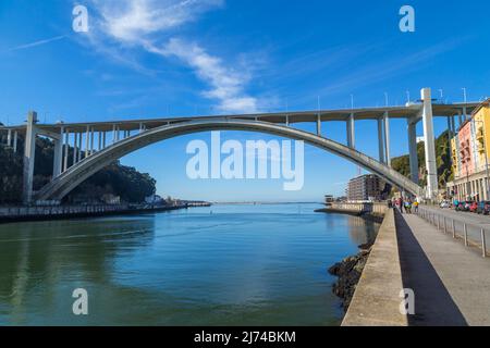 PORTO, PORTUGAL - März 5. 2022: Touristen und Einheimische genießen einen schönen frühen Frühlingstag am Douro-Fluss und der Arrabida-Brücke in Porto C Stockfoto