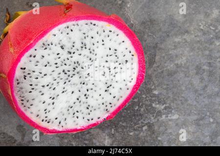 Drachenfrucht-Scheiben auf grau melierter Oberfläche und reichlich Platz für Kopien Stockfoto