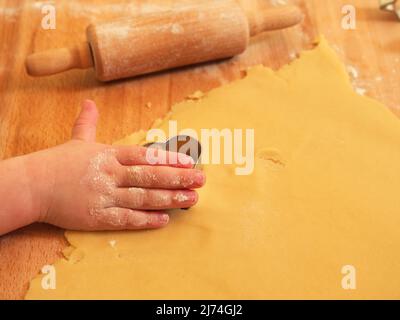 Das Foto zeigt eine Nahaufnahme einer kleinen Kinderhand mit dem Ausstechform Stockfoto