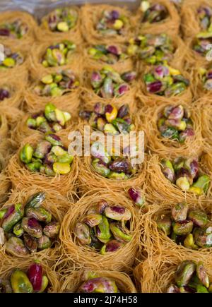 Platte mit Nachtigallen-Nestern oder Ouch El Boulboul. Arabisches Dessert mit Pistazie Stockfoto