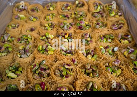 Platte mit Nachtigallen-Nestern oder Ouch El Boulboul. Arabisches Dessert mit Pistazie Stockfoto