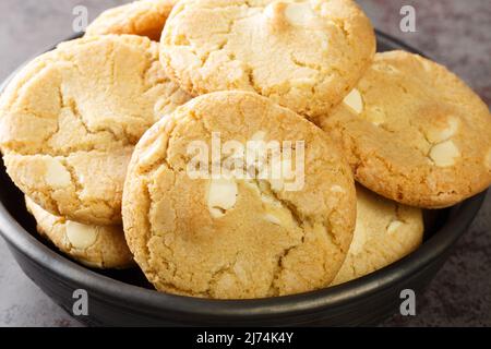 Haufen weißer Schokoladensplitter und Macadamianusskekse auf dem Tisch aus nächster Nähe. Horizontal Stockfoto