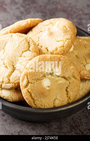 Shortbread-Kekse mit Macadamia-Nüssen und weißer Schokolade aus nächster Nähe. Vertikal Stockfoto