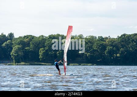 Zegrze, Polen - 25. Juli 2020: Windsurfen auf dem Zegrze See. Erholung, aktive Zeit auf dem Wasser. Windsurfmann. Stockfoto